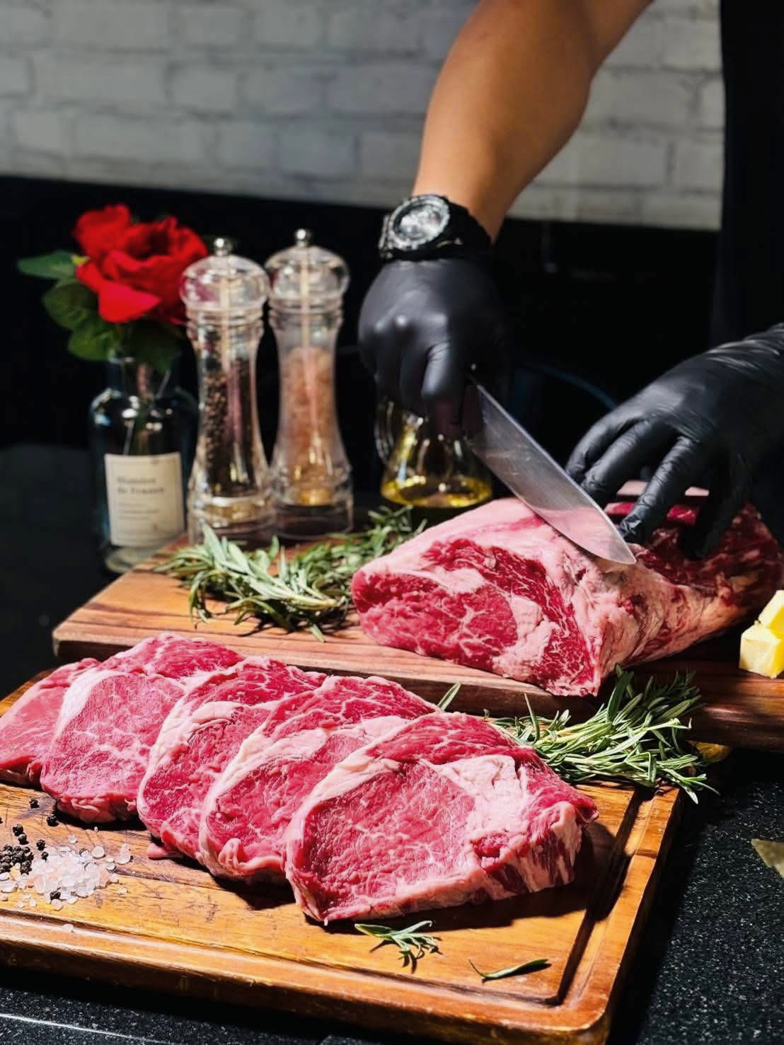 Raw marbled beef being sliced at X BEEF