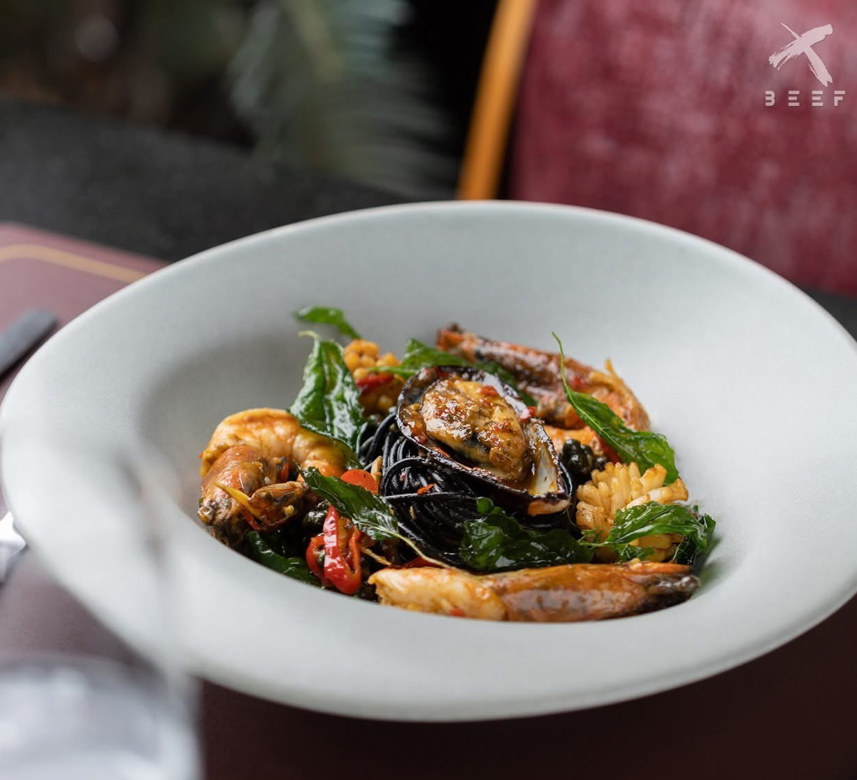 X BEEF pasta in a white bowl